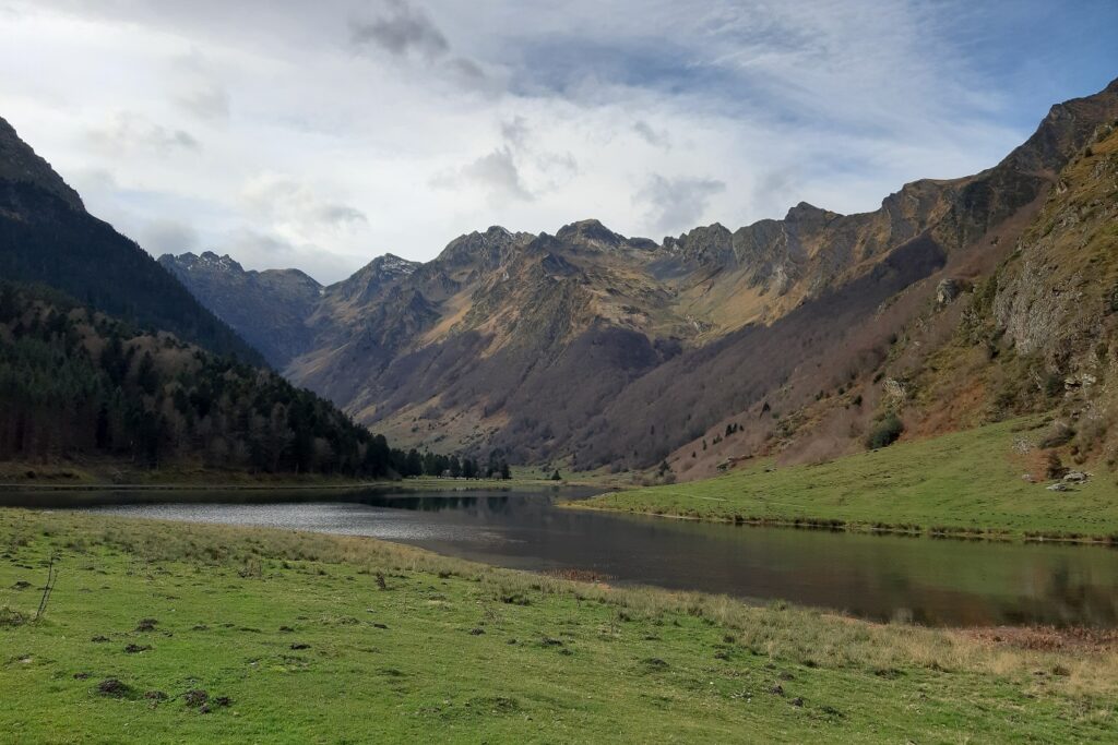 paysage de montagne couvert avec au premier plan un espace vert et au second plan des sommets, avec au centre de l'image un cours d'eau qui passe. Ce paysage est observable lors de l'étape 3 du GR10 entre Lescun et Cauteret