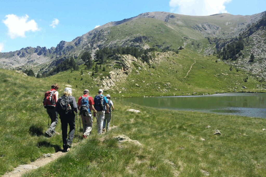 Groupe de randonneurs sur un sentier se dirigeant vers un lac de montagne entre Cauterets et Luchon