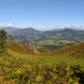 paysage estival avec en contrebas une vallée et en contre-haut des paysages verts dus au temps estival