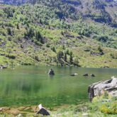 Lac de montagne entouré de sommets et de végétation