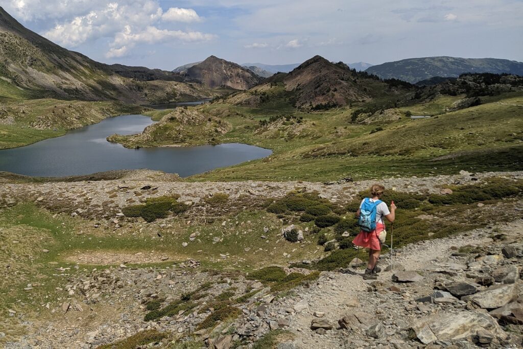 Groupe de randonneurs sur un sentier avec leur guide, paysage de montagne avec un lac en contrebas