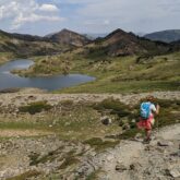 Groupe de randonneurs sur un sentier avec leur guide, paysage de montagne avec un lac en contrebas