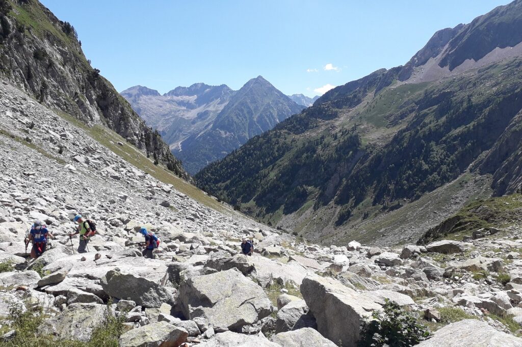 Grope de randonneurs en été sur un sentier avec leur guide être l'Aneto et le pic d'Estats