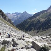 Grope de randonneurs en été sur un sentier avec leur guide être l'Aneto et le pic d'Estats