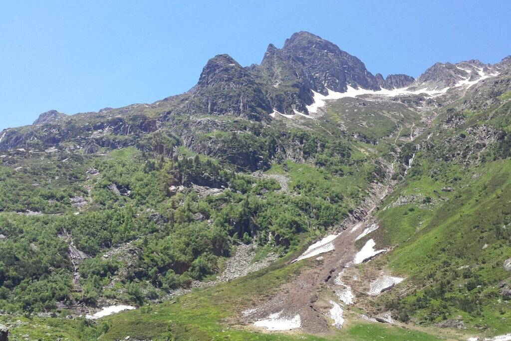 Paysage de montagne contenant une montagne avec de la neige au pied de cette dernière