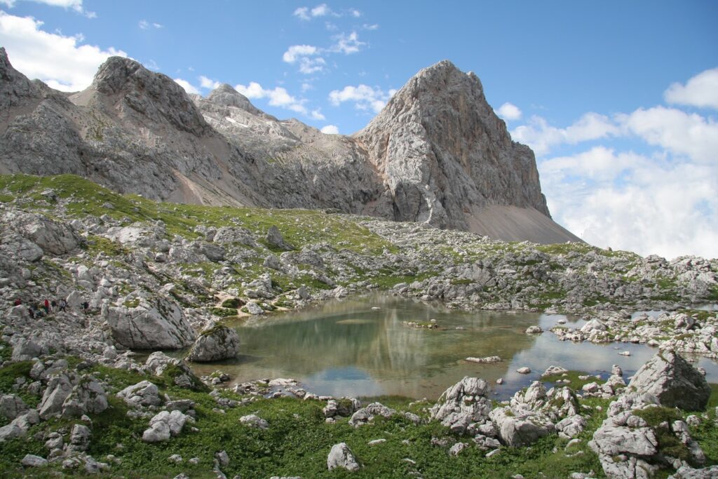 Paysage de montagne avec des sommets de la végétation ainsi qu'un cours d'eau, en Slovénie dans les Alpes juliennes