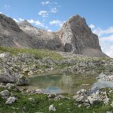 Paysage de montagne avec des sommets de la végétation ainsi qu'un cours d'eau, en Slovénie dans les Alpes juliennes