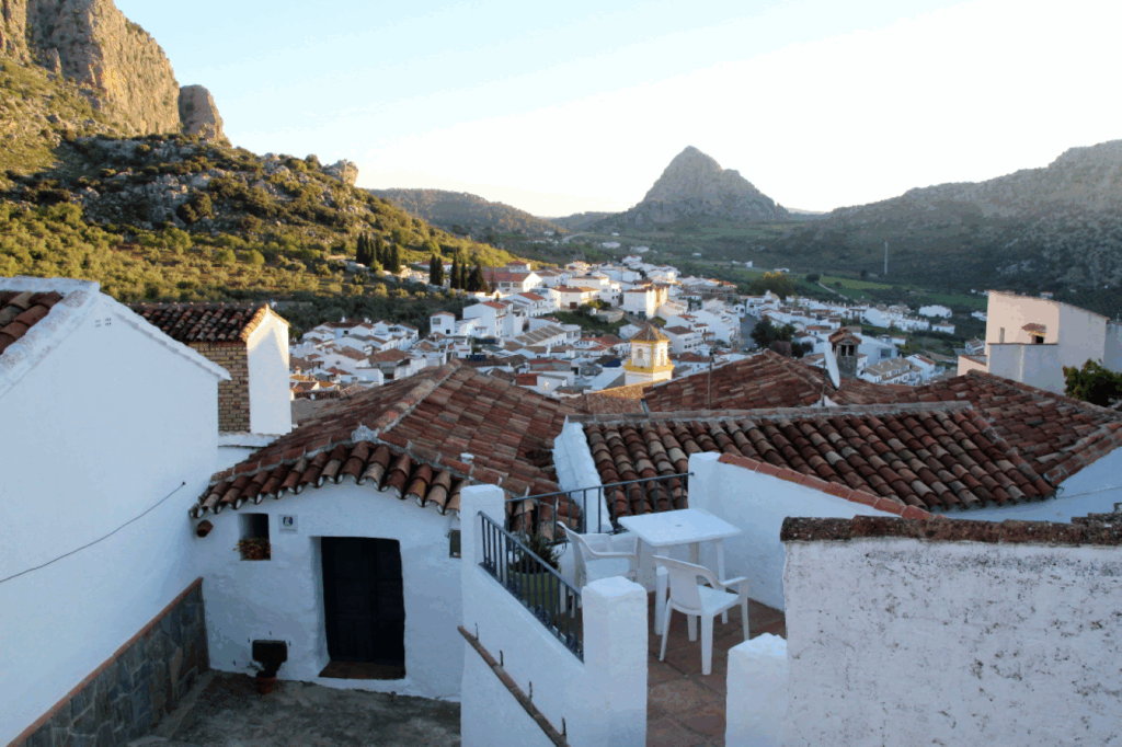 Paysage andalou au coucher du soleil avec des maisons blanches au premier plan et des sommets à l'arrière