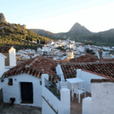 Paysage andalou au coucher du soleil avec des maisons blanches au premier plan et des sommets à l'arrière