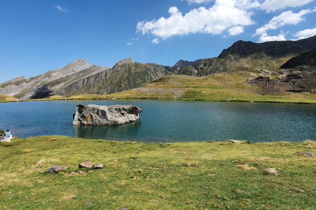 Paysage de montagne avec des sommets en roche grise en arrière-plan et au premier plan un lac