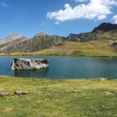 Paysage de montagne avec des sommets en roche grise en arrière-plan et au premier plan un lac