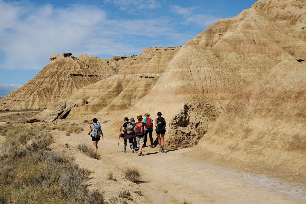 Groupe de randonneurs sur un paysage des bardenas caractéristique du paysage sec de la zone