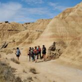 Groupe de randonneurs sur un paysage des bardenas caractéristique du paysage sec de la zone