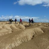 Groupe de randonneurs sur un terrain de Bardenas, sur la terre sèche due au climat, accompagné par leur guide