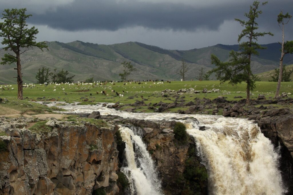 Paysage mongol contenant une cascade et au loin des sommets