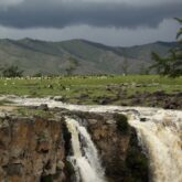 Paysage mongol contenant une cascade et au loin des sommets