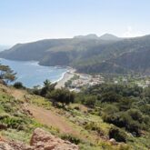 Prise de vue en hauteur d'un paysage de bord de mer en crête avec des montagnes créant une baie sur l'île.