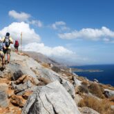 Groupe de randonneurs sur un sentier de montagne avec la mer en contrebas en Crète