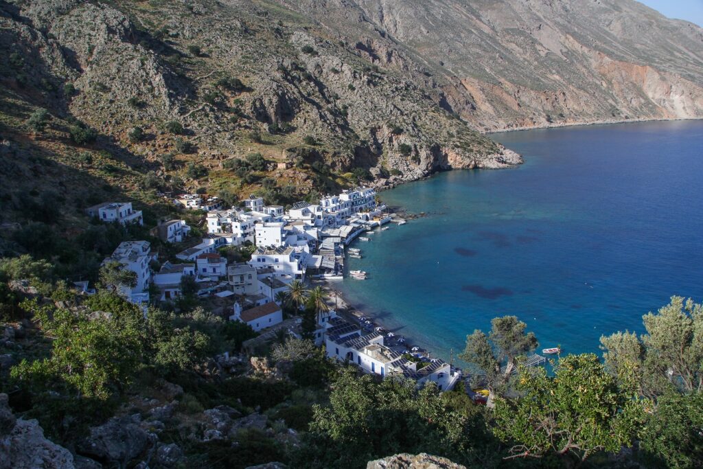 Paysage observé sur l'île de Crète avec une baie formée par les montagnes ainsi qu'un village en contrebas, constitué de maisons blanches, très typique de la Grèce et de ses îles