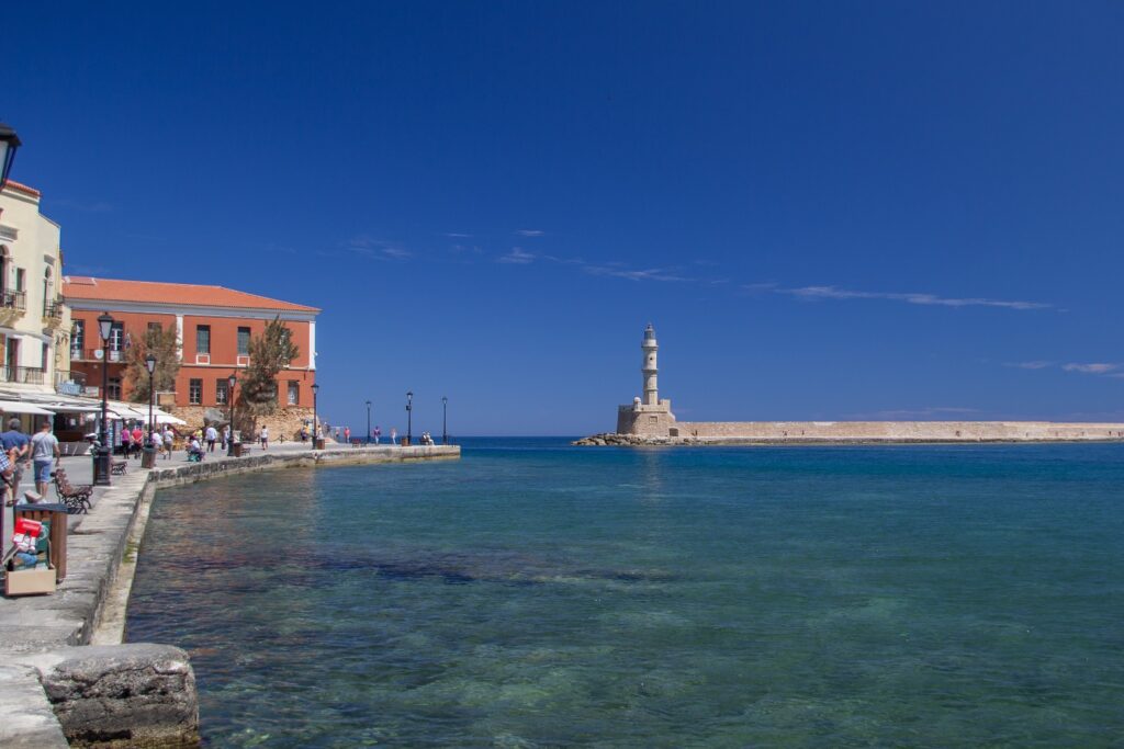 Paysage de ville de bord de mer en Crète avec la mer et l'eau turquoise ainsi que des constructions sur la gauche