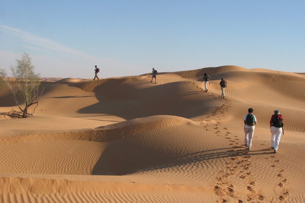Groupe de randonneurs en train de faire une randonnée à travers les dunes du Maroc