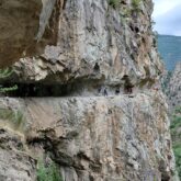 Groupe de randonneurs sur un sentier à flanc de montagne ancré dans la montagne
