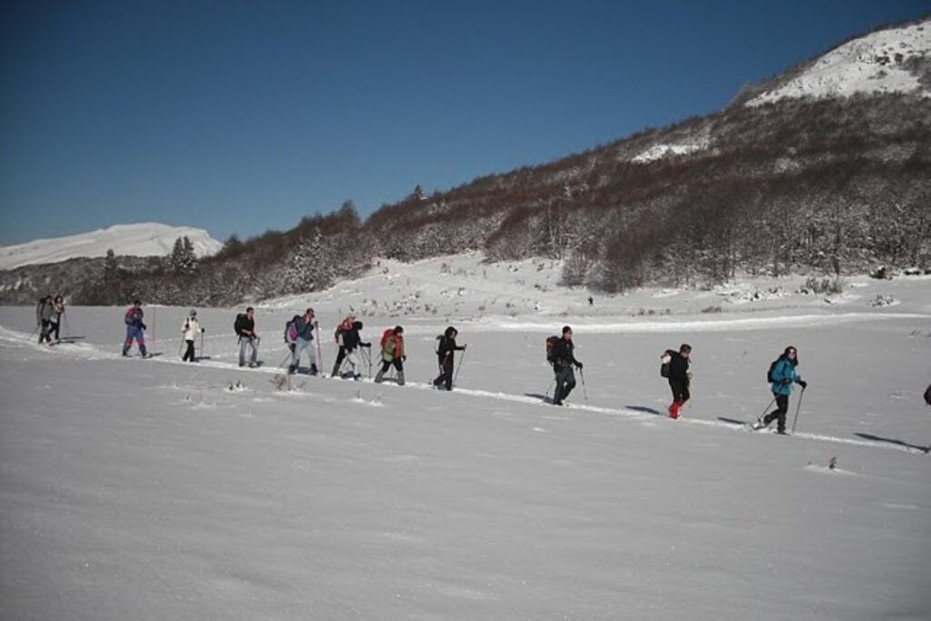 groupe de randonneurs en raquette qui font leur trace dans la neige en suivant leur guide, au cours d'un séjour raquette dans la vallée d'Ax