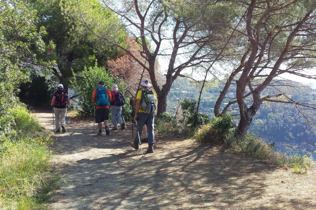 Groupe de randonneurs sur un sentier de montagne sur les hauteurs d'un village des cinque terres.