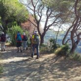 Groupe de randonneurs sur un sentier de montagne sur les hauteurs d'un village des cinque terres.