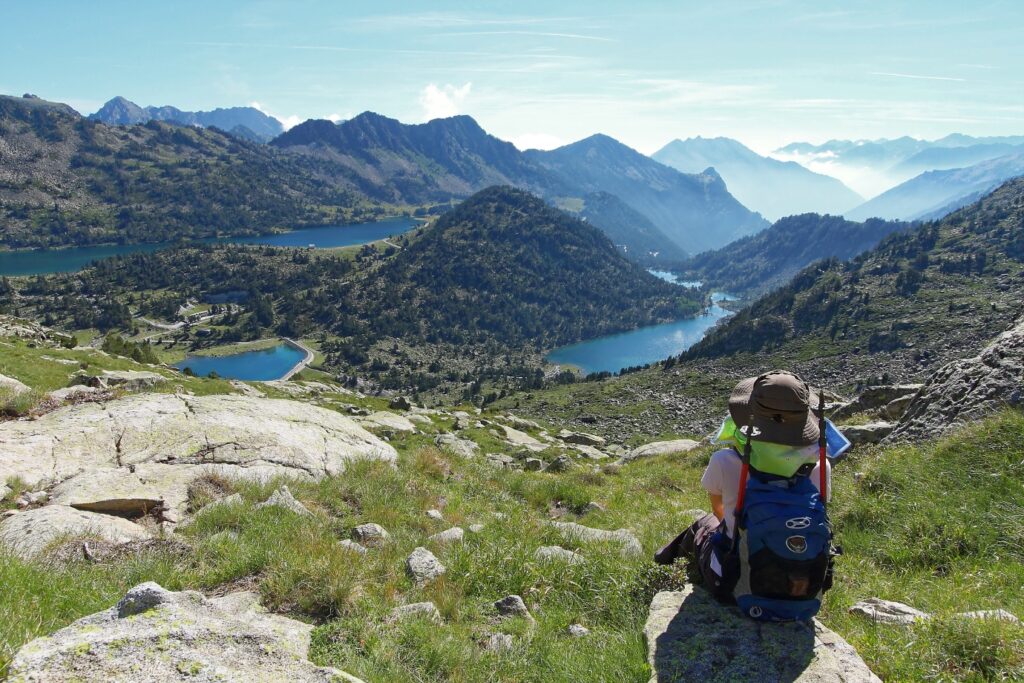 Groupe de montagnards devant la vue avec des lacs et en face des sommets.