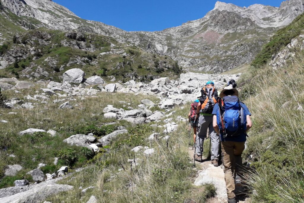 Groupe de randonneurs s'avançant dans des sentiers montagnards au cours d'une randonnée accompagnée par un guide au coeur de l'Aneto.