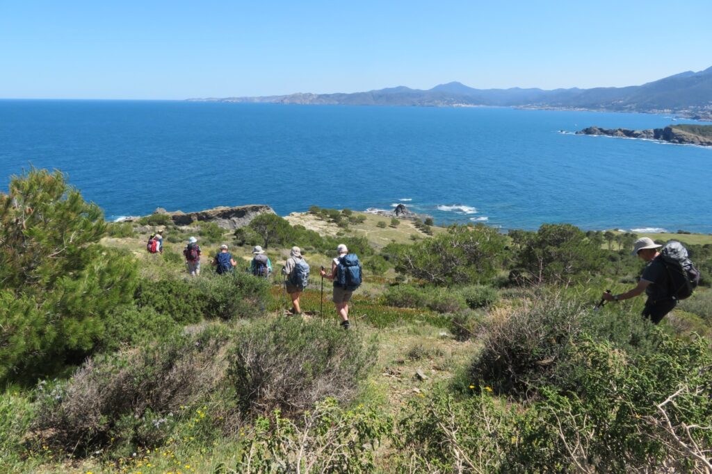 Groupe de randonnée s’avançant sur un sentier face à la mer