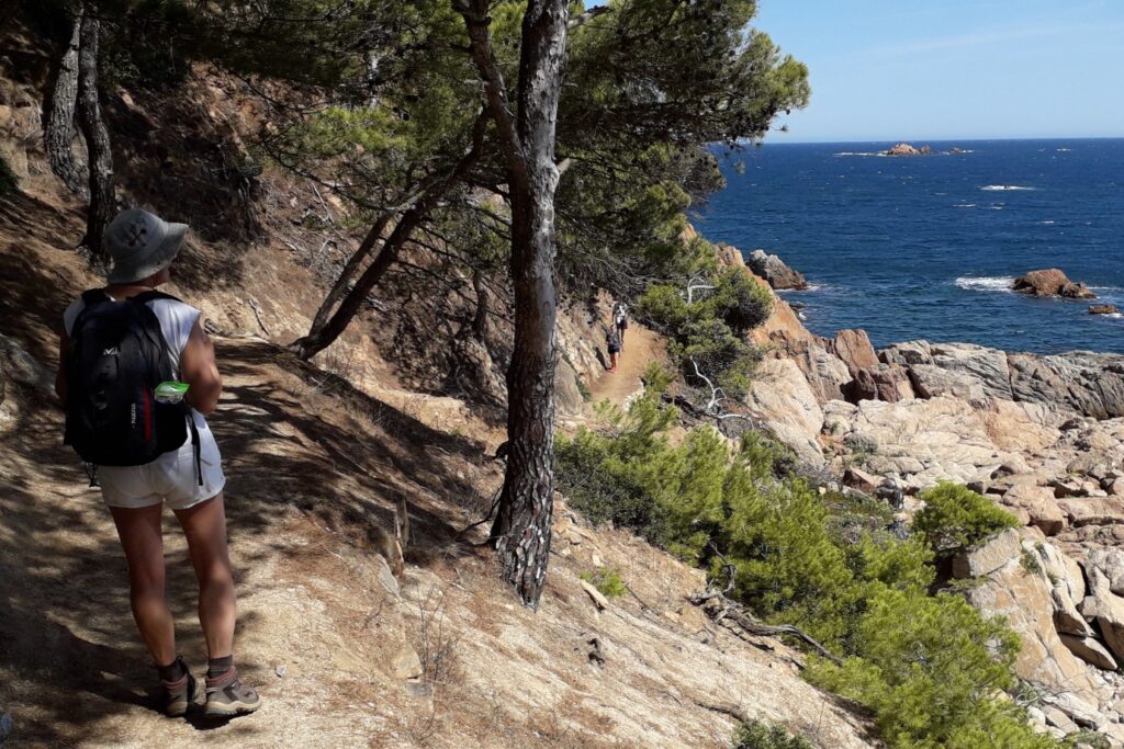 Groupe de randonneurs se dirigeant sur un sentier le long de la mer en Costa Brava