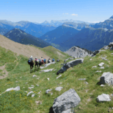 Groupe de randonneurs sur un sentier de montagne avec leur guide, et de nombreux sommets derrière eux sur le circuit Gavarnie Ordesa