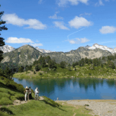 Groupe de randonneurs au bord d'un lac de montagne sur un sentier