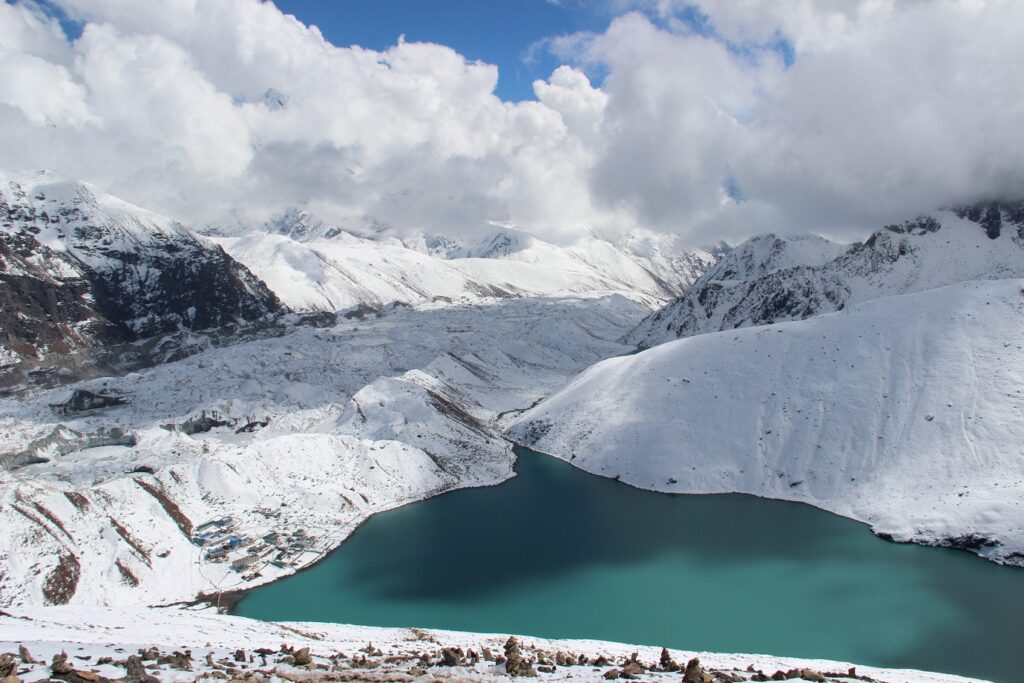 Paysage montagnard au Népal avec un lac bleu au milieu des montagnes enneigées