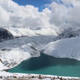 Paysage montagnard au Népal avec un lac bleu au milieu des montagnes enneigées