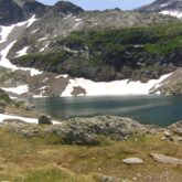 Lac de montagne avec en arrière-plan des montagnes couvertes de neige