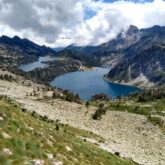 Paysage de montagne avec au premier plan un sentier de montagne, puis au second plan un lac et finalement des sommets au plus loin