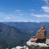 Paysage montagnard avec en fond des sommets enneigés et au premier plan un cairn