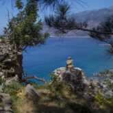 Paysage de Crète avec en contrebas la mer encadrée de montagnes, la prise de vue est faite depuis une montagne couverte d'arbres