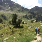 Groupe de randonneurs sur un sentier de pierre face à la montagne dans les encartas