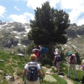 Groupe de randonneurs sur un sentier de randonnée aux abords d'un lac de montagne dans les Encantats