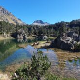 Lac de montagne encadré d'arbres et de sommets dans les encartais