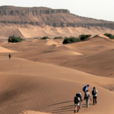 Groupe de randonneurs dans la vallée du Draa à travers les dunes