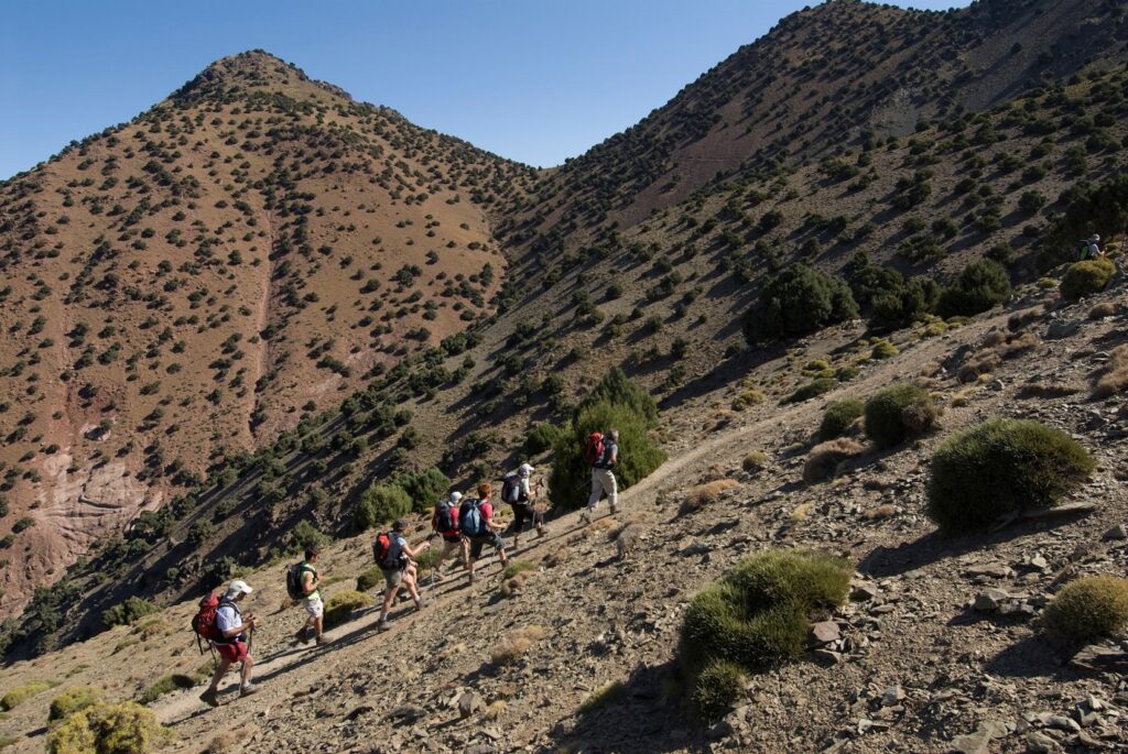groupe de randonneurs avec leur guide sur un sentier en train de monter le toubkal