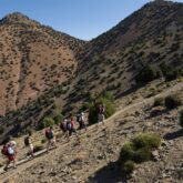 groupe de randonneurs avec leur guide sur un sentier en train de monter le toubkal