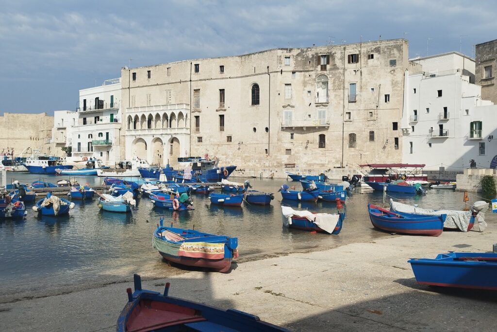 Paysage d'Italie avec un port contenant des bateaux et des monuments blancs comme dans le reste des Pouilles du sud