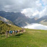 Groupe de randonneurs sur un sentier de la haute randonnée pyrénéenne avec leur guide