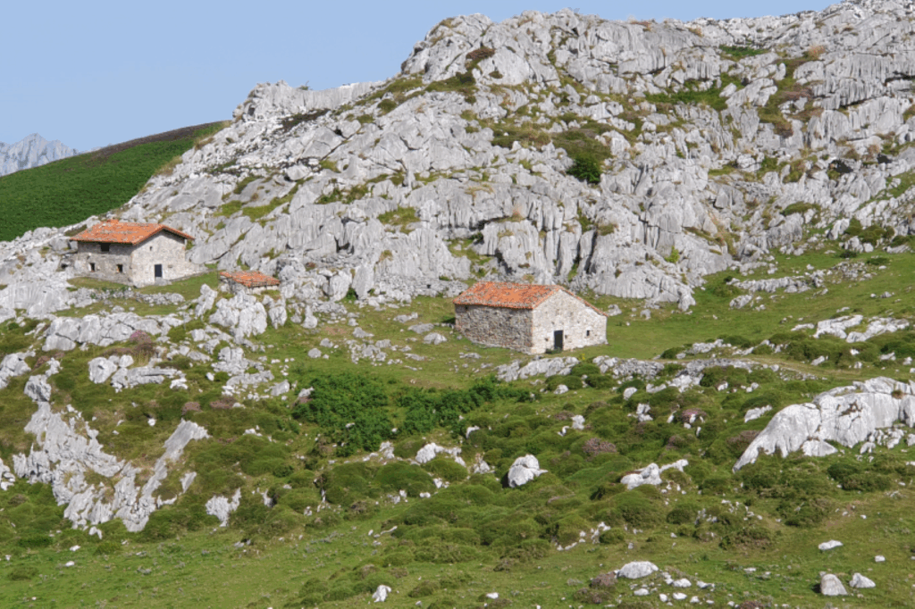 Paysage des picos de europas avec des maisons en pierre à travers la verdure et les montagnes